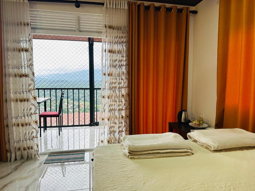 a bedroom with a bed and a large window at Mount Vista Homestay Kandy in Kandy