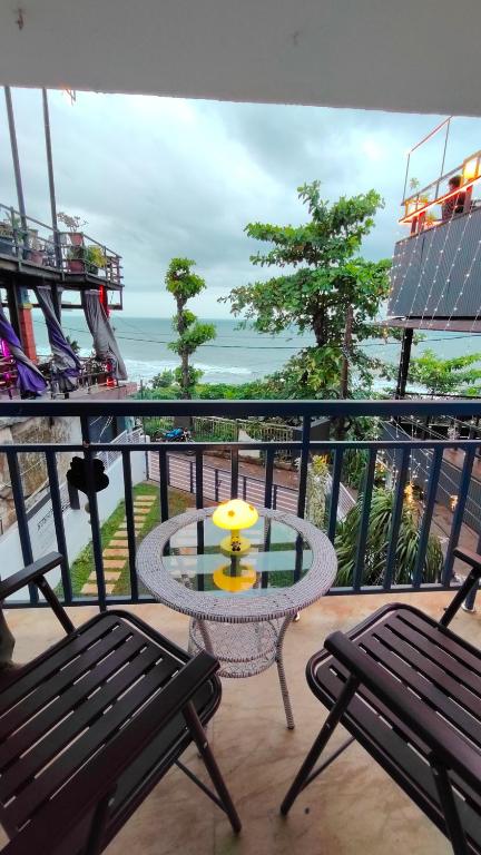 a balcony with a table and two chairs and the ocean at Avanthi Homestay in Varkala