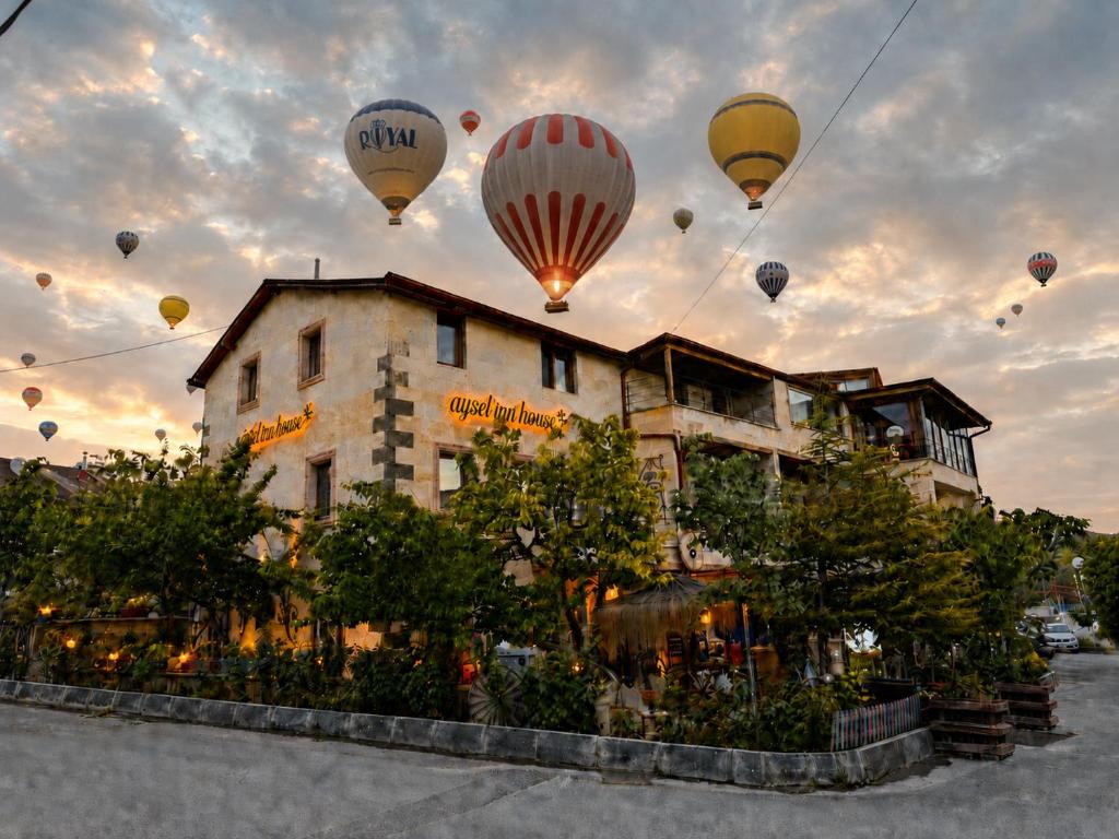 a group of hot air balloons flying over a building at Aysel Inn House in Göreme
