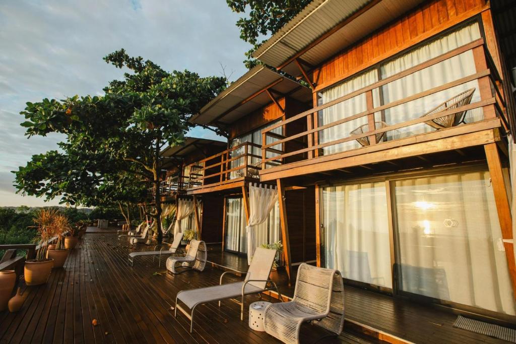 a porch of a house with chairs and windows at Ilha do Mel Lodges in Ilha do Mel