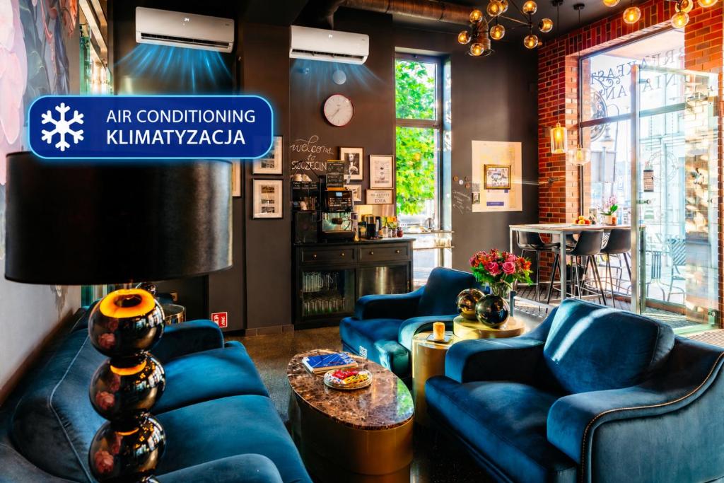 a room with blue couches and a sign that reads art conditioning kimanooga at Cocorico Bed and Breakfast OLD TOWN Szczecin Adults Only in Szczecin