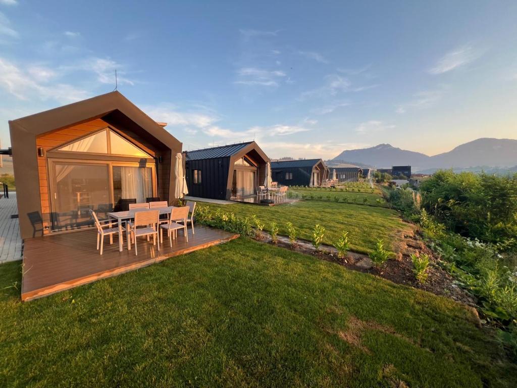 a house with a deck with a table and chairs at Rekreačné domy Marina Cabin House in Bobrovník