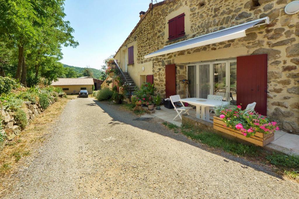 a house with a table and chairs outside of it at Le Duzon avec Piscine in Saint-Sylvestre