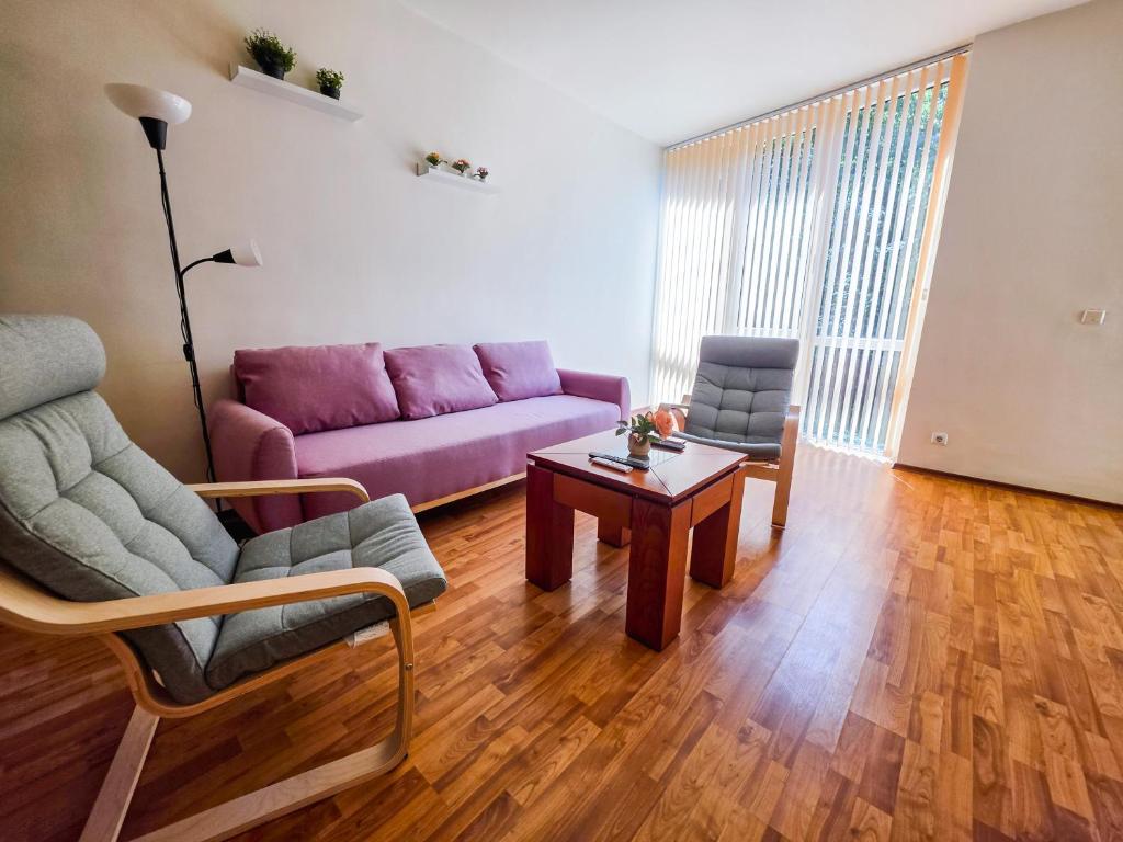 a living room with a purple couch and a table at Tranquil condo in Golden Sands in Varna City
