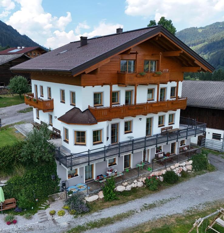 a large white building with a wooden roof at Apartments Unterfischergut in Flachau