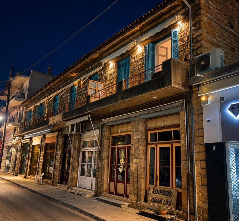 an old brick building with a balcony on a street at Edipsos Serenity Suites in Loutra Edipsou