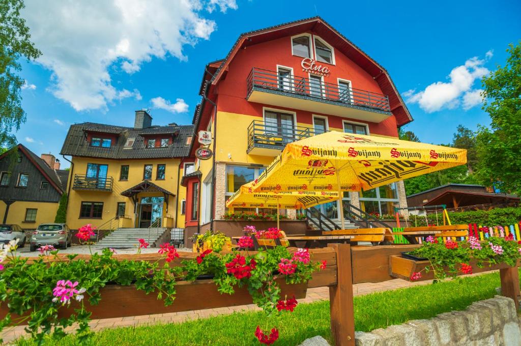 a yellow umbrella in front of a building at Pensjonat Etna - w Centrum in Szklarska Poręba