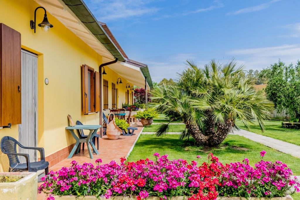 a patio of a house with pink flowers at Le Terre Di BAC in Borgo Montenero