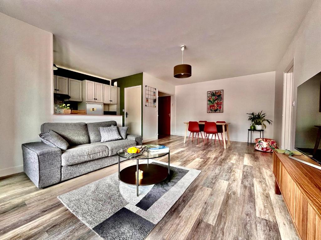 a living room with a couch and a table at Eden-Novia in Orléans
