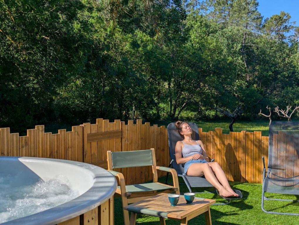 a woman sitting in a chair next to a hot tub at Les Nuits Nordiques in Bras