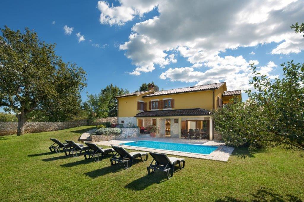 a house with a swimming pool in a yard at Vila Charlie in Labin