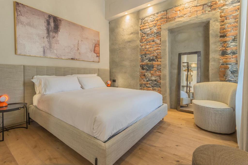 a bedroom with a bed and a brick wall at La Corte Del Lario - San Giorgio in Varenna