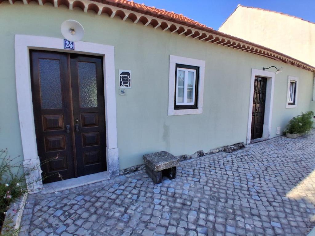 a house with a door and a bench in front of it at Casa do Ti Maurício in Gondemaria