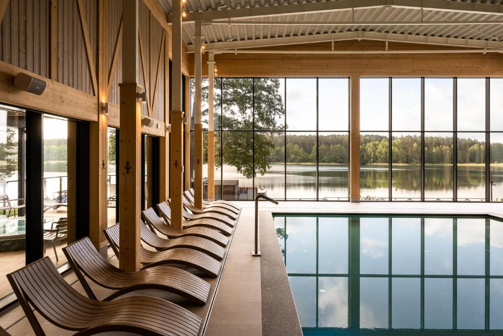 a row of benches in a building with a pool at Aries Lago Park Hotel & SPA, Mazury in Olsztynek