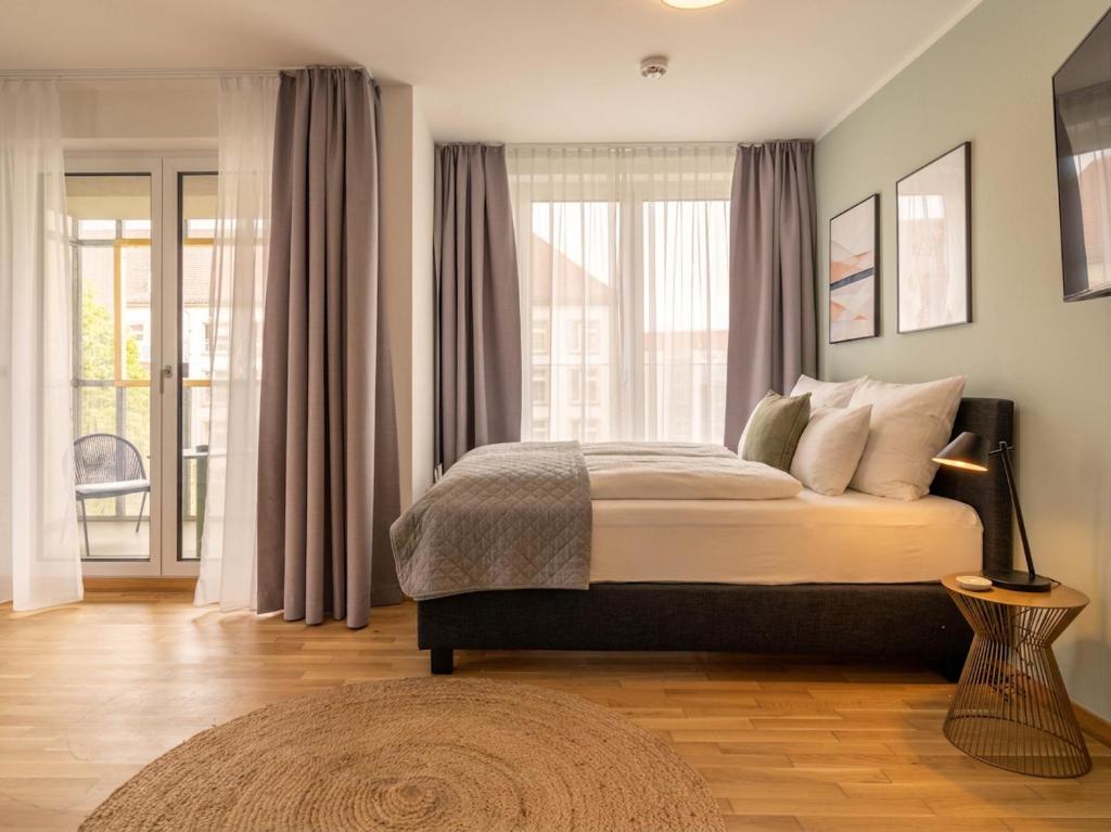 a bedroom with a bed and a large window at Limehome Dresden Wallstraße - Digital Access in Dresden