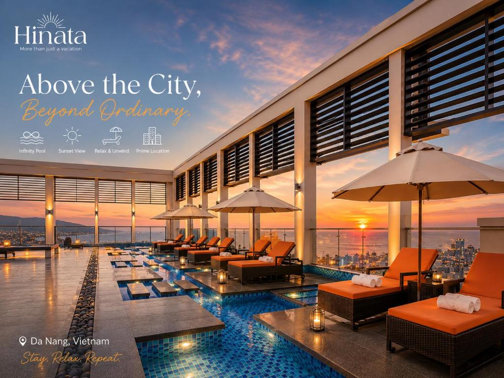 a hotel lobby with a pool with chairs and umbrellas at Luxury Apartment - Rooftop Swimming Pool - Beach Front - Hinata Apartment in Danang