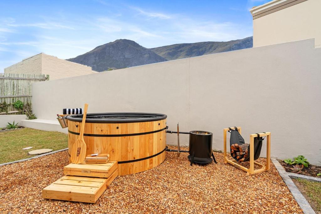 a wooden barrel sitting on the ground next to a wall at 8 on Nivenia in Bettyʼs Bay