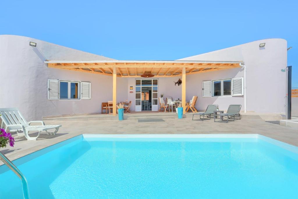 a villa with a swimming pool and a house at Villa Brisa de Gairia in Antigua