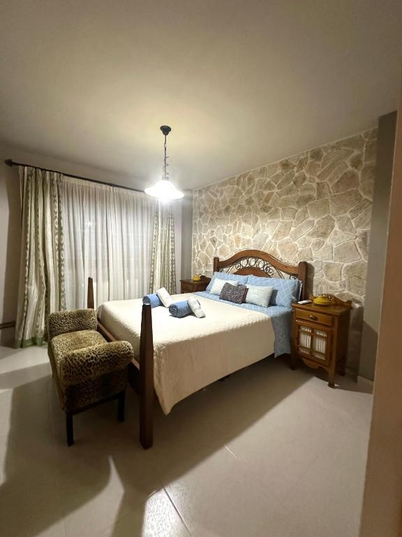 a bedroom with a large bed and a chair at Es Cantonet in Calvià