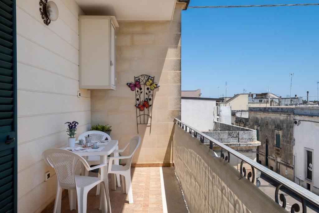 a balcony with a table and chairs on a building at Le Crapare in Muro Leccese