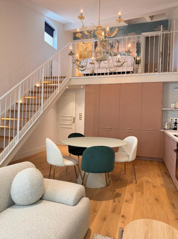 a dining room with a table and chairs and a staircase at Duplex charmant dans le centre - La suite Incas in Le Puy-en-Velay