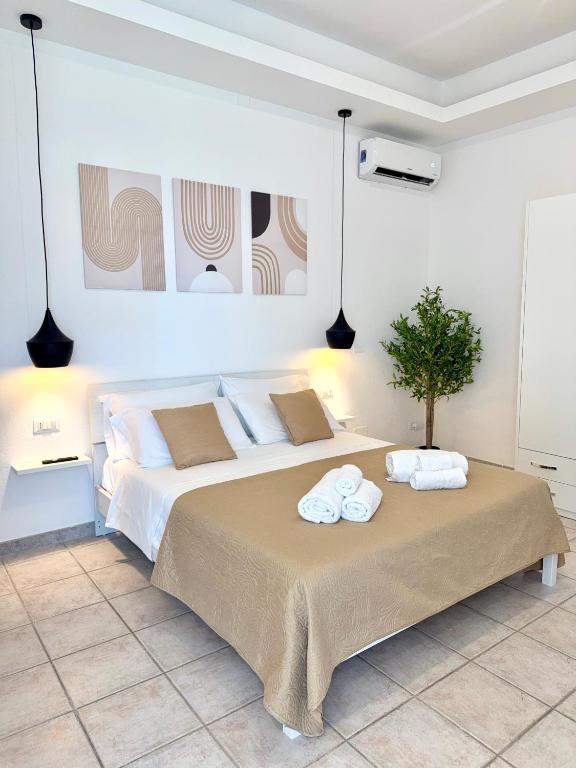 a bedroom with a large bed with towels on it at S'Olivare Posada - Apartments in Posada