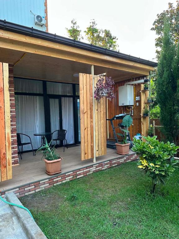 a house with a wooden deck with potted plants at Chaki 2 in Ureki