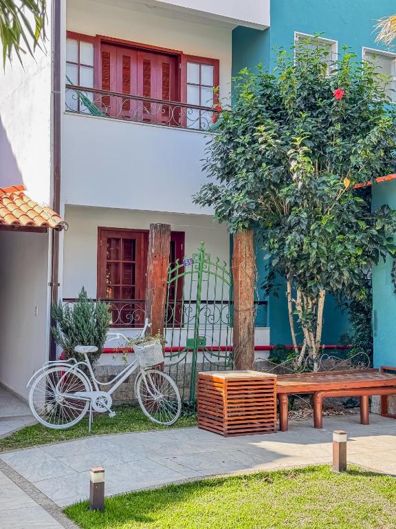 a bike parked next to a building with a bench at Vila Hibisco Pousada e Apart in Vassouras