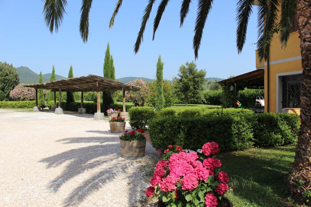 a garden with pink flowers and a gazebo at Agriturismo Eucaliptus in Bolgheri