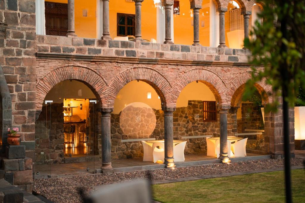 a building with arches and tables in a courtyard at Casa Cartagena Boutique Hotel & Spa in Cusco
