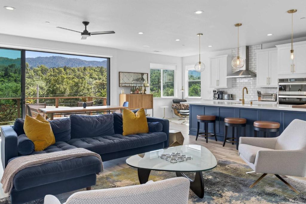 a living room with a blue couch and a kitchen at Chardonnay Getaway in Glen Ellen