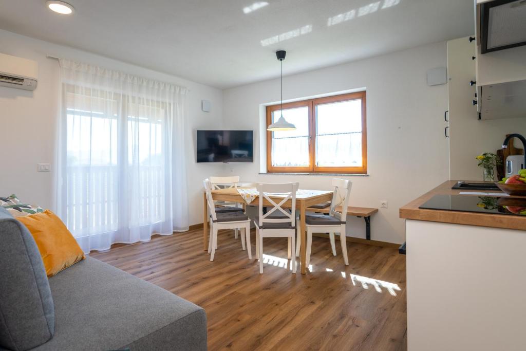 a kitchen and dining room with a table and chairs at Start Point Apartments in Žirovnica