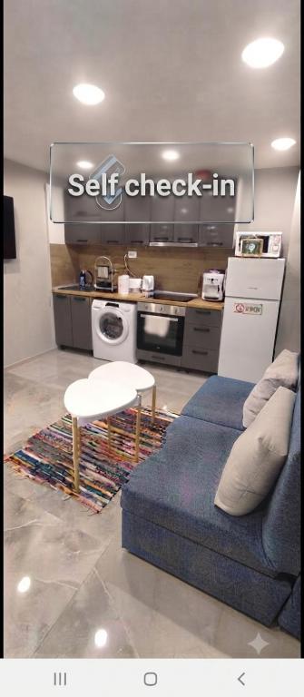 a living room with a blue couch and a kitchen at Uptown Funk in Ruse
