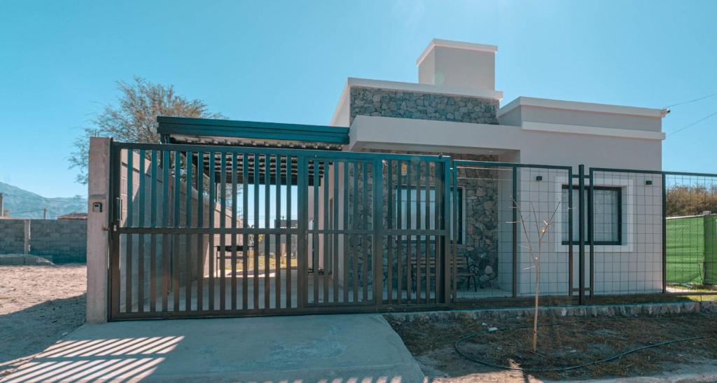 a building with a gate in front of a house at Casa Tannat by Vindecaf in Cafayate
