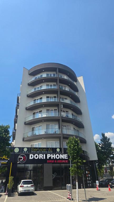 a tall building with a sign in front of it at Corner Apartments in Tirana