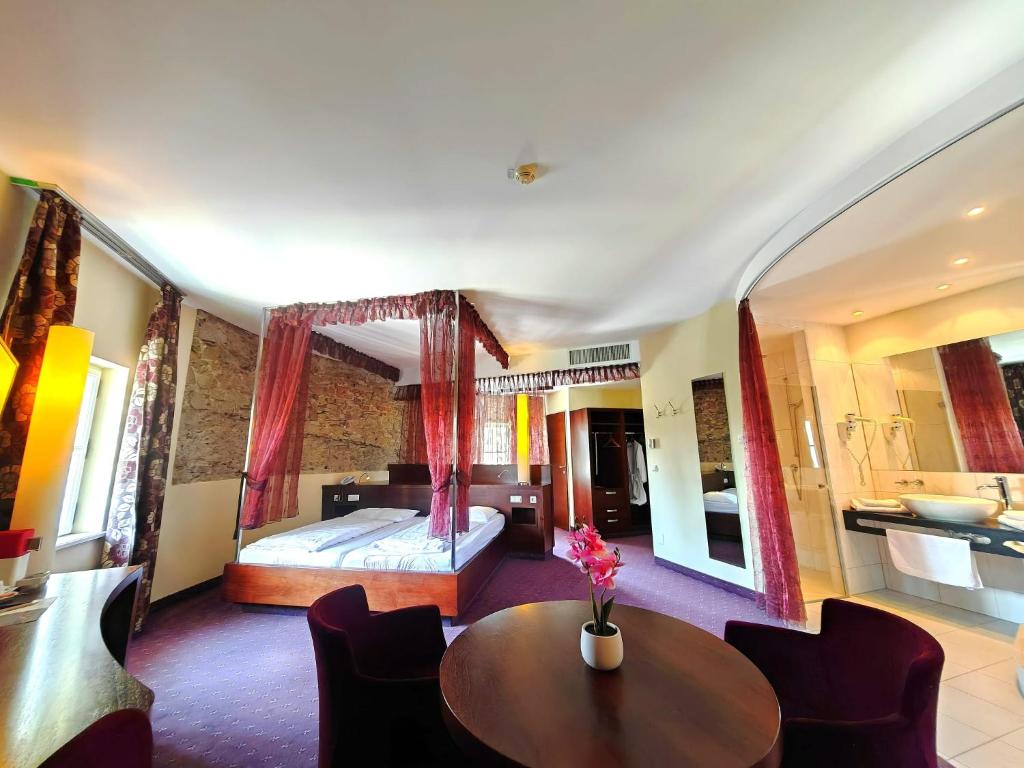 a bedroom with a bed and a table and chairs at Hotel Öhlknechthof in Horn