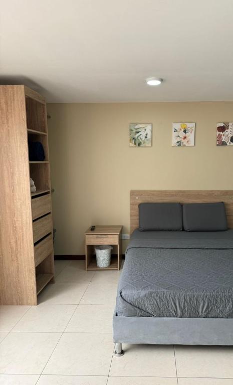 a bedroom with a bed and a wooden cabinet at Hostelfc San Luis in Bogotá