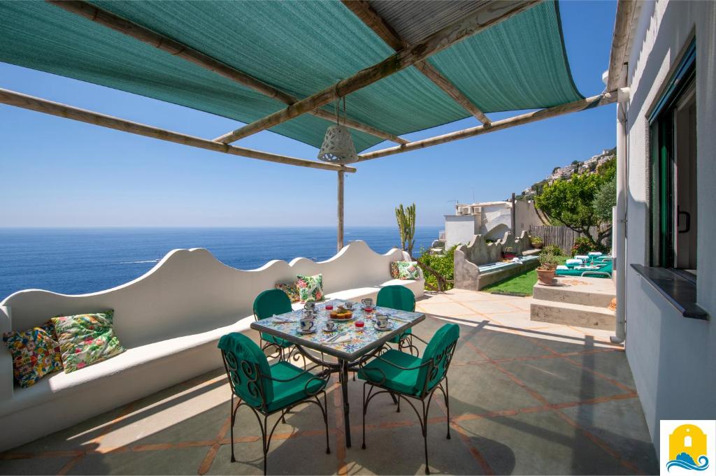 a patio with a table and chairs and the ocean at Casa Francisca in Praiano