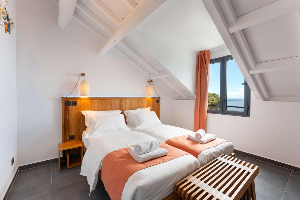 two beds in a room with white walls at L'Astrolabe in Vieux-Fort