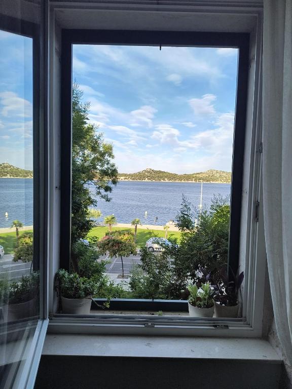 an open window with a view of the water at Apartment Oliveto Sibenik in Šibenik