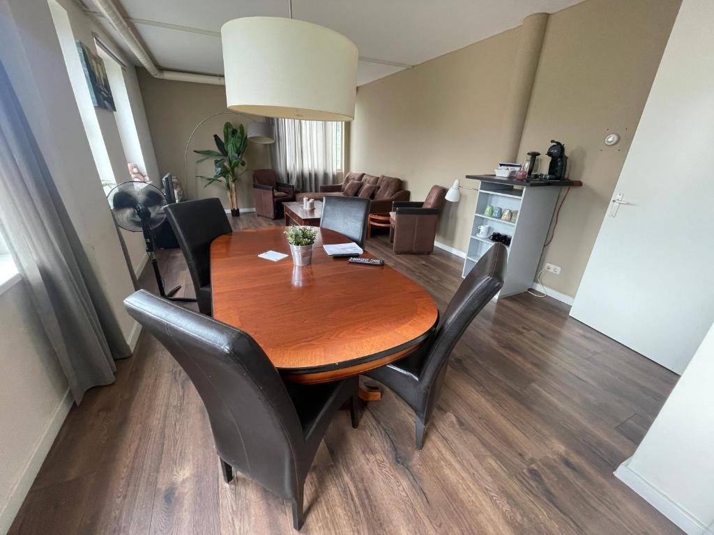 a dining room and living room with a wooden table and chairs at TopSleep Apartments 26-1 in Arnhem