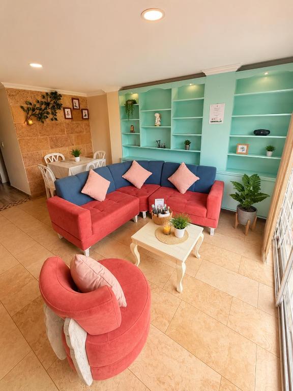 a living room with two red couches and a table at Hospedaje Edificio Alejandria in Sogamoso