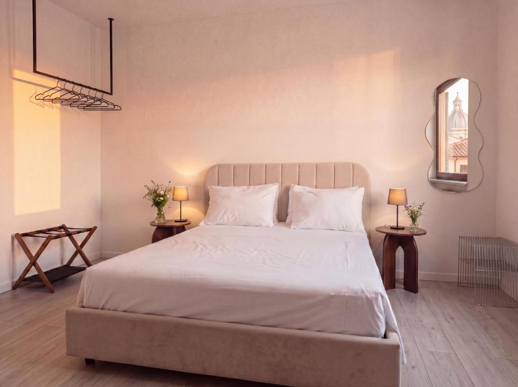 a bedroom with a large white bed with two tables at OverGarden Rooms in Dossobuono