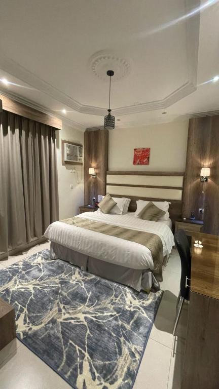 a bedroom with a large bed and a large rug at أجنحة ورد للشقق المخدومة in Khamis Mushayt