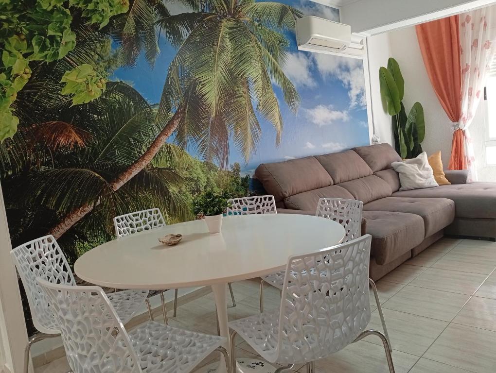 a living room with a table and chairs and a couch at Alma Brizo Suites in Grao de Castellón
