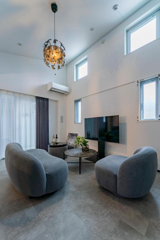 a living room with two chairs and a fireplace at SLL Urban Suites Ebisu in Tokyo