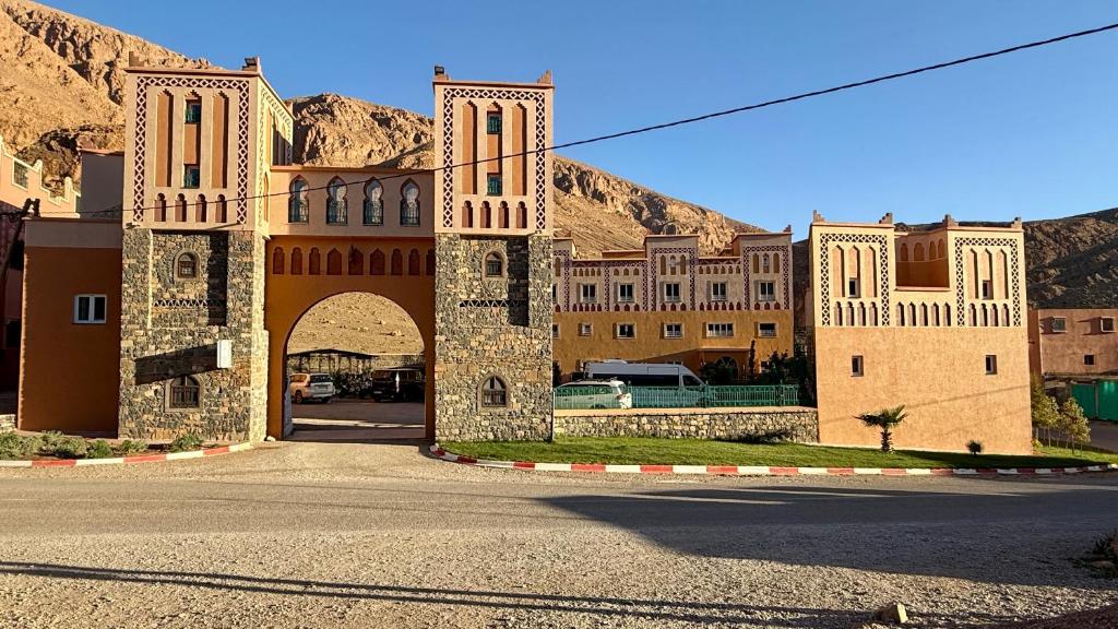 a building with an arch in the middle of a street at Hotel New Mars Dades in Aït Idaïr