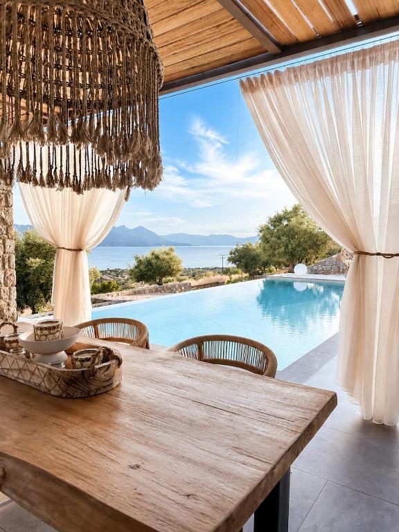 a dining table with a view of a pool at Villa Melisea in Sfendoúrion