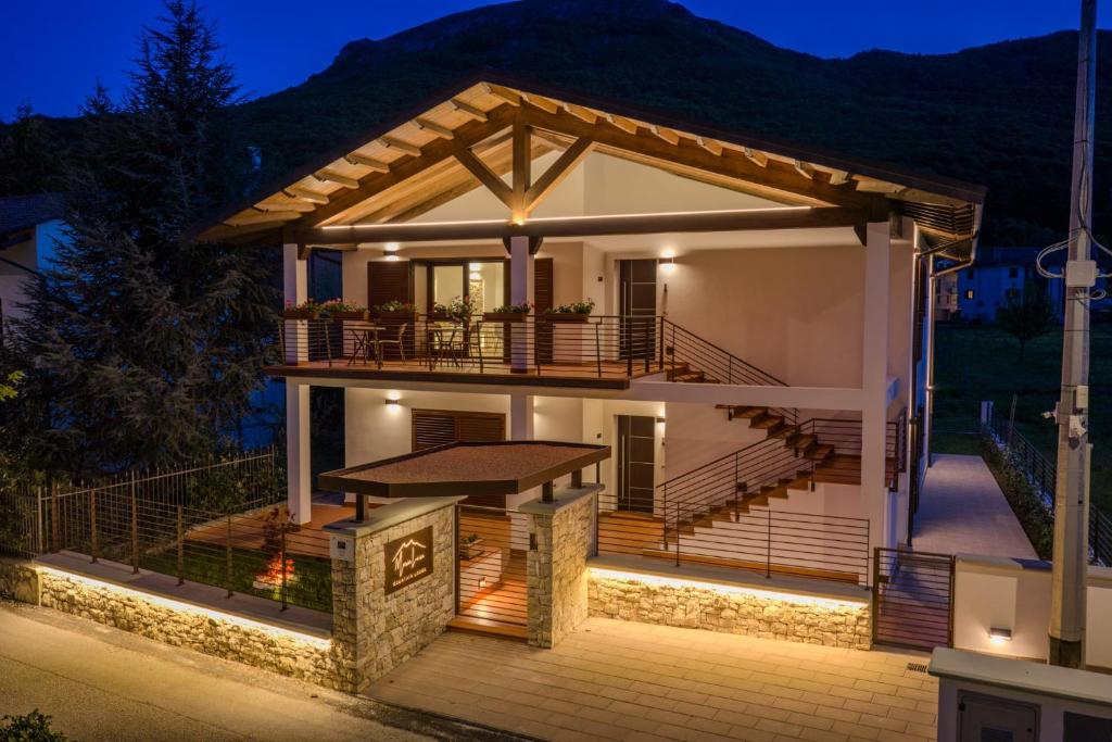 a house with a large deck at night at Maria Luisa Mountain Lodge in Rovere