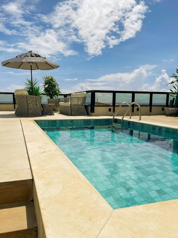 a swimming pool with an umbrella on a balcony at Carppa Hotel in Fortaleza